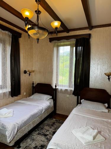two beds in a room with two windows at EDEMS dilijan villa in Hovkʼ