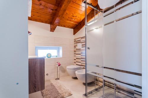 een badkamer met een glazen douchecabine en een toilet bij Casa Vacanza Diadema in Matera