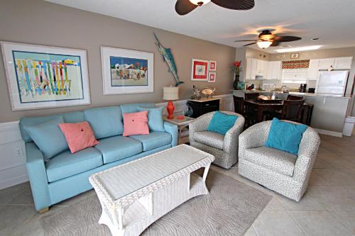 a living room with a blue couch and two chairs at Bayview in Orange Beach