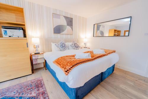 a bedroom with a large bed and a mirror at Spacious 7 Bedroom 5 Bathroom Mansion with Parking in Cardiff