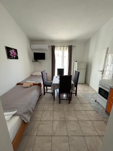 a room with a bed and a table and chairs at Apartmani Paklenica in Razvala
