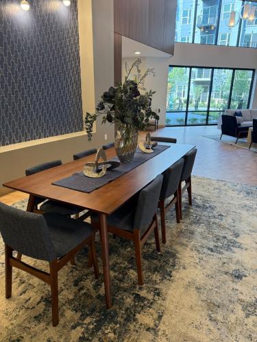 a dining room table with chairs and a vase of flowers at Modern & Spacious Stay in Prime Location Parking in Richmond