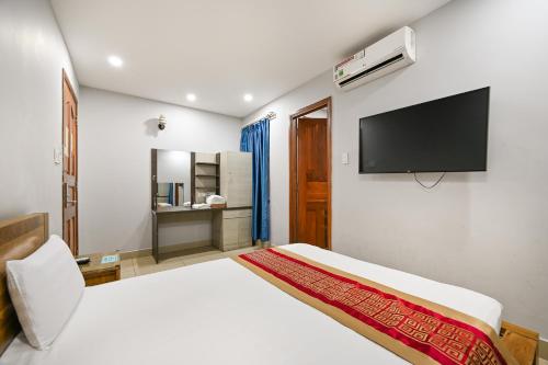 a bedroom with a bed and a flat screen tv at Gio Hotel - near Nam Saigon International Hospital in Ho Chi Minh City