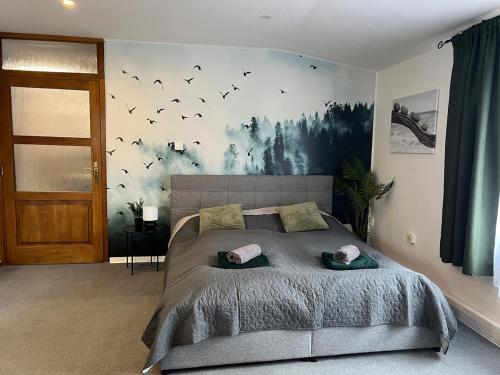a bedroom with a large bed with birds on the wall at Apartmán Turista in Martin