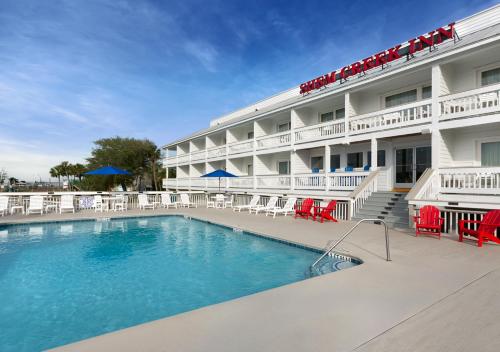 a hotel with a swimming pool in front of a building at Shem Creek Inn in Charleston