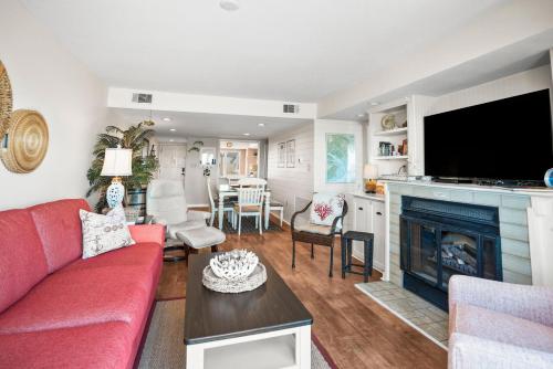 a living room with a red couch and a fireplace at 630 New Haven - Dolphin Pointe in Fripp Island