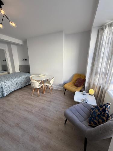 a bedroom with a bed and a table and a couch at Beautiful Central Brighton l Sea View I Spacious Studio Flat I Sleep 2-3 Guests in Brighton & Hove