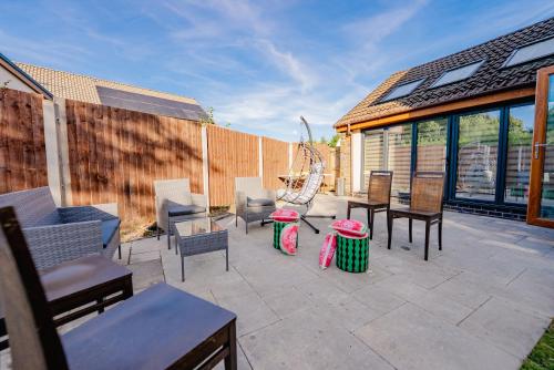 a patio with chairs and tables and a fence at Spacious 7 Bedroom 5 Bathroom Mansion with Parking in Cardiff