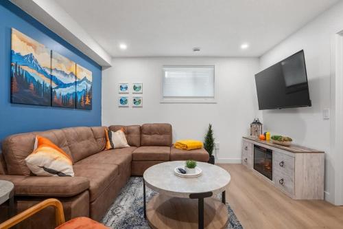 a living room with a couch and a flat screen tv at Meadowstone Suite 3BD 3 TVs Near Spruce Meadows in Calgary