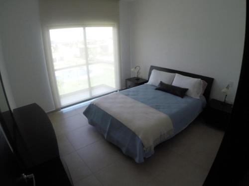 ein Schlafzimmer mit großem Bett und Fenster in der Unterkunft Departamento Paraiso Country Club-Morelos in Emiliano Zapata