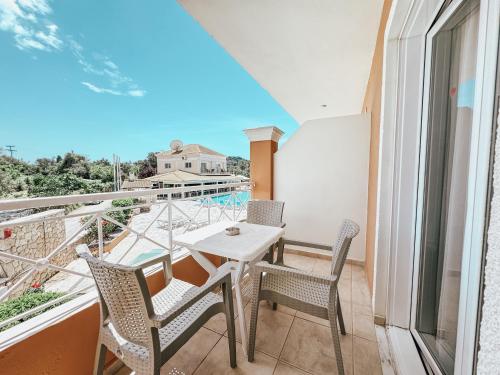a balcony with a table and chairs and a view at Kavos Plaza Hotel in Kavos