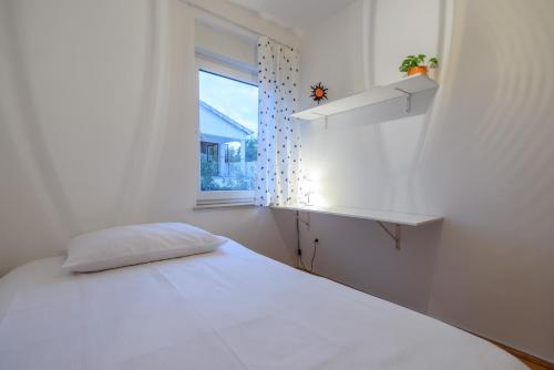 - une chambre blanche avec un lit et une fenêtre dans l'établissement Apartment Kristy, à Zadar