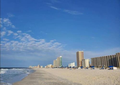 a beach with buildings and chairs and the ocean at Cozy 2BD/2BA w/ View, Sleeps 6 in Orange Beach