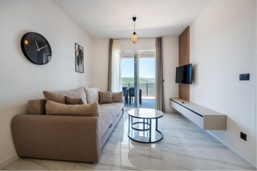 a living room with a couch and a clock on the wall at Villa Kristina in Neum