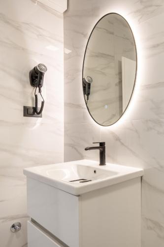 a white bathroom with a sink and a mirror at Villa Kristina in Neum