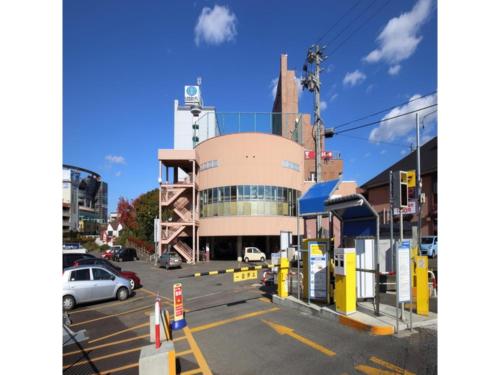 a parking lot with a gas station in front of a building at Smile Hotel Hirosaki - Vacation STAY 40509v in Hirosaki