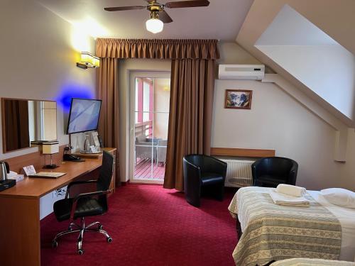 a hotel room with a bed and a desk and chairs at Aura - Hotel & Restaurant & Sauna in Zielona Góra