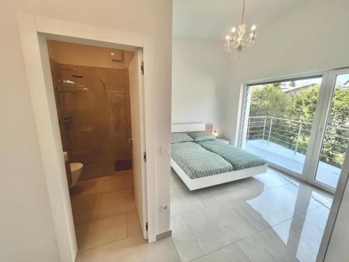 a bedroom with a bed and a bathroom with a window at 4 Bedroom Private House On The Hill in Ljubljana
