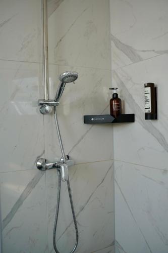 a shower with a shower head in a bathroom at PrimeBnb Schönbrunn in Schönbrunn
