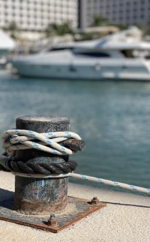 a pile of ropes on a dock with a boat in the water at Caesar Premier Eilat Hotel in Eilat