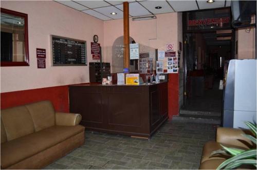 a restaurant with a counter and a bar in a room at Hotel Victoria in Puebla
