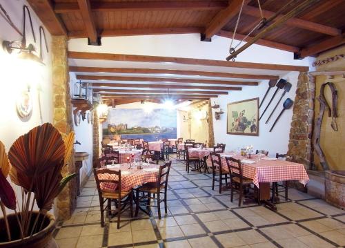 un restaurante con mesas y sillas en una habitación en Hotel Alceste, en Marinella di Selinunte