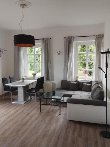 a living room with a couch and a table at Gut Rottmannshagen Mecklenburgische Seenplatte in Jürgenstorf