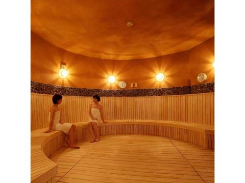 two women sitting on a bench in a room at Quad Inn Yokote - Vacation STAY 57366v in Yokote