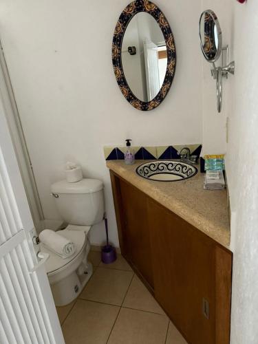 a bathroom with a toilet and a mirror at La Pirámide del Tepozteco in Tepoztlán