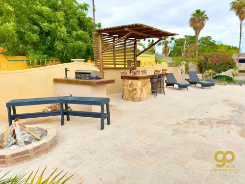a patio with a grill and benches and a bar at Casa Caracol Beachfront and Private Pool Villa in El Centenario