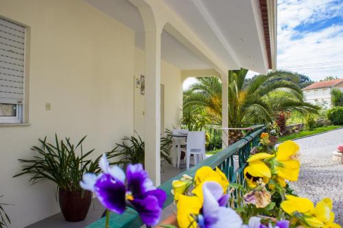 a porch with yellow and purple flowers on it at Escondidinho do Vez, LDA in Arcos de Valdevez