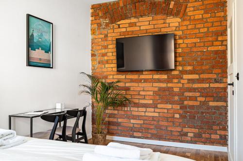 a brick wall with a tv on a wall at Blick Apartments - Soft Loft in Zgorzelec