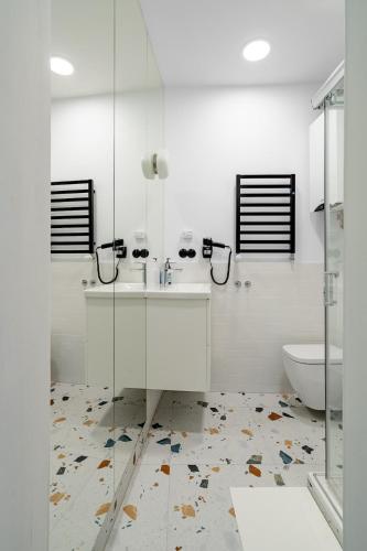 a white bathroom with a sink and a toilet at Blick Apartments - Soft Loft in Zgorzelec