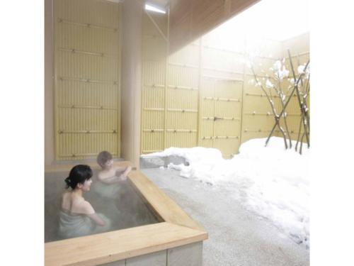 a man and a woman in a hot tub at Quad Inn Yokote - Vacation STAY 57397v in Yokote