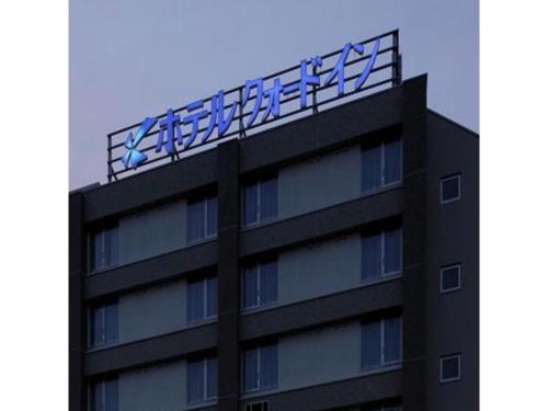 a building with a sign on the top of it at Quad Inn Yokote - Vacation STAY 57389v in Yokote