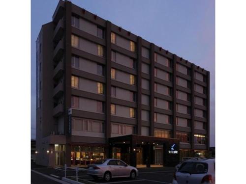 a building with two cars parked in front of it at Quad Inn Yokote - Vacation STAY 57389v in Yokote