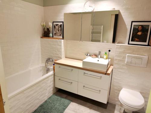 une salle de bain avec un lavabo, des toilettes et une baignoire dans l'établissement Logement cosy Sous Les Toits, à Charmes-sur-Rhône