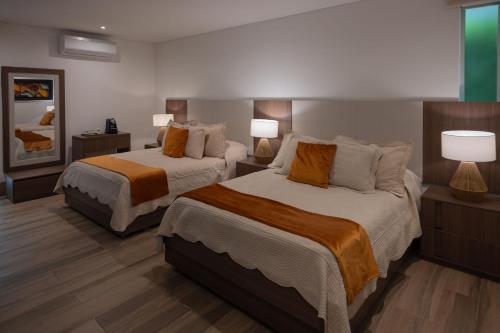a hotel room with two beds and two lamps at Hotel Campestre Montecarlo in Montenegro