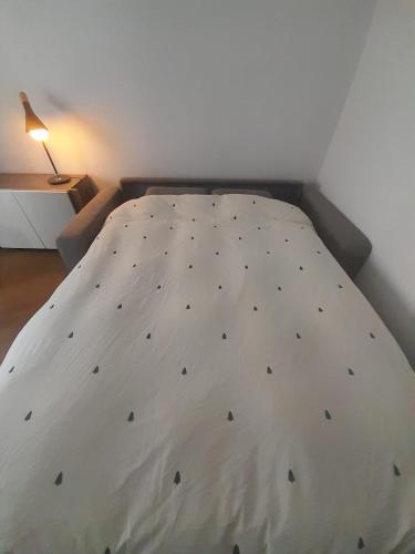 un lit blanc avec des carrés noirs dessus dans une pièce dans l'établissement Baccarat - Cristal Appartement - 25m2, à Baccarat