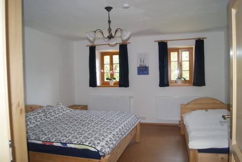 1 dormitorio con 1 cama y 2 ventanas en Ferienhaus Bioeck, en Mühlgraben