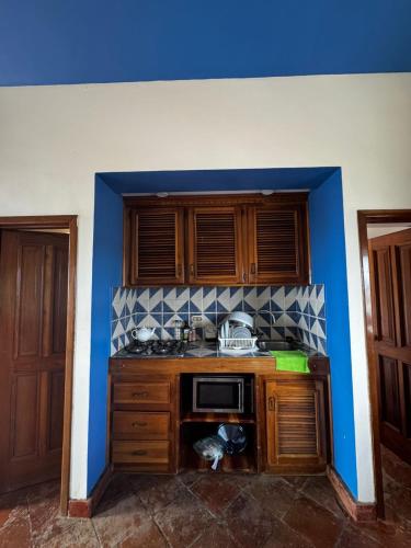 a kitchen with a stove and a blue wall at Las Palmeras by Graziano in Boca Chica