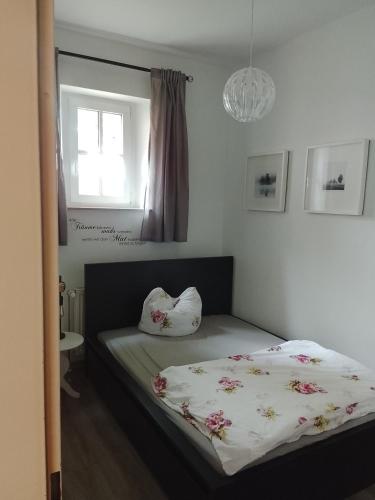 a bedroom with a bed with a white blanket and a window at Gut Rottmannshagen Mecklenburgische Seenplatte in Jürgenstorf