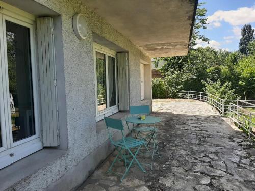 une table et des chaises assises sur le côté d'une maison dans l'établissement Appartement T1 bis proche centre ville, à Figeac