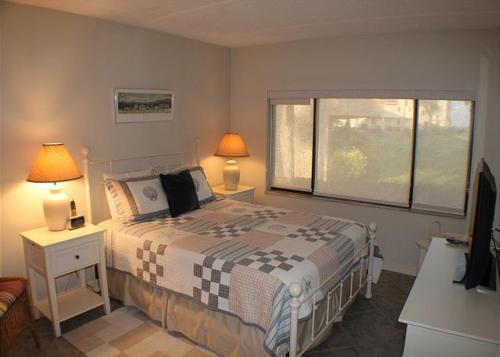 a bedroom with a bed with two lamps and a window at Summerhouse 228 in Saint Augustine