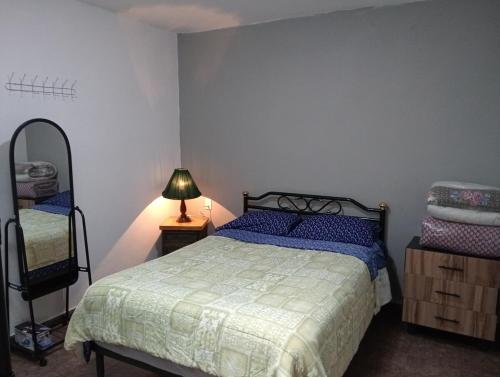 a bedroom with a bed and a lamp and a chair at Estancia merry in Cedro