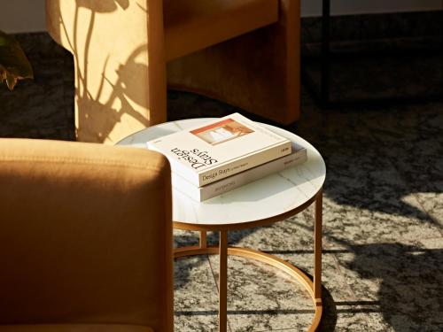 two books sitting on a table next to a chair at Numa Berlin Arc in Berlin