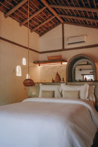 a bedroom with a large bed with white pillows at Anacardier Privé Hotel in Atins