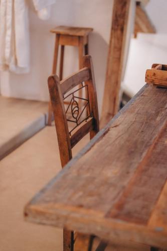 a wooden table with a wooden chair next to at Anacardier Privé Hotel in Atins