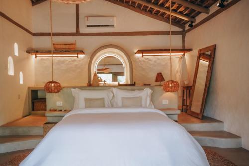 a bedroom with a large white bed in a room at Anacardier Privé Hotel in Atins