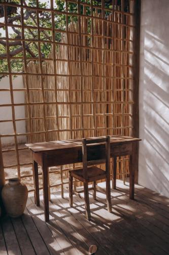 a wooden table with a bench and a chair at Anacardier Privé Hotel in Atins